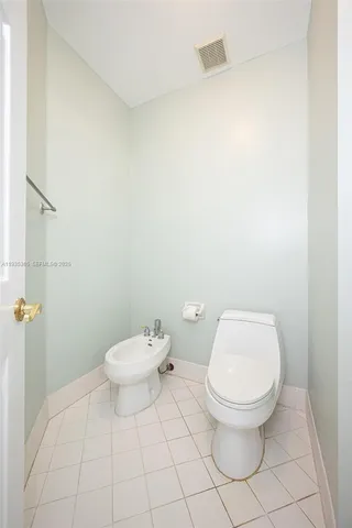 a white toilet sitting next to a white wall