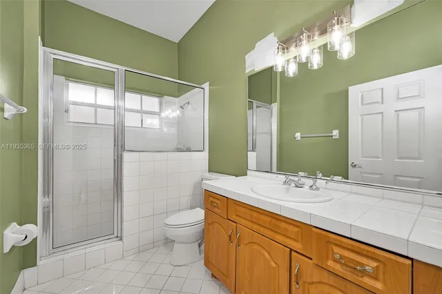 a bathroom with a double vanity sink mirror and toilet