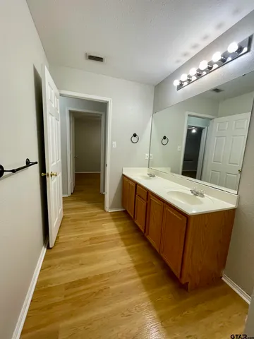 a spacious bathroom with a double vanity sink and mirror