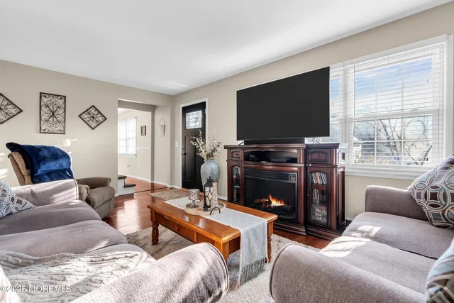 a living room with furniture a flat screen tv and a fireplace