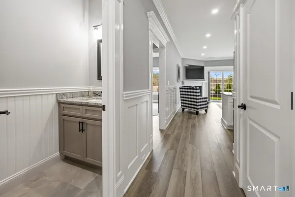 a view of a hallway with wooden floor and cabinets