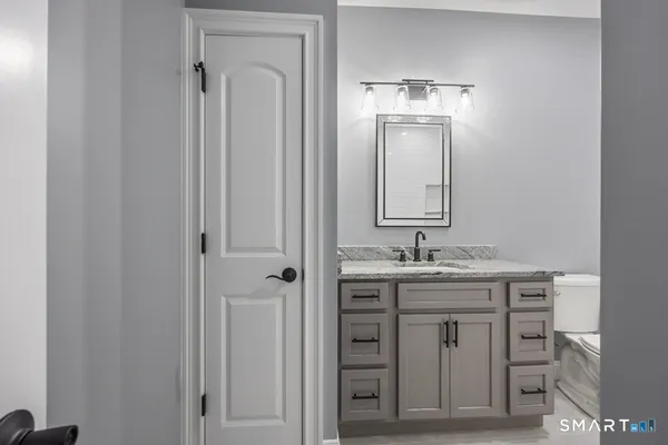 a bathroom with a granite countertop sink and a mirror