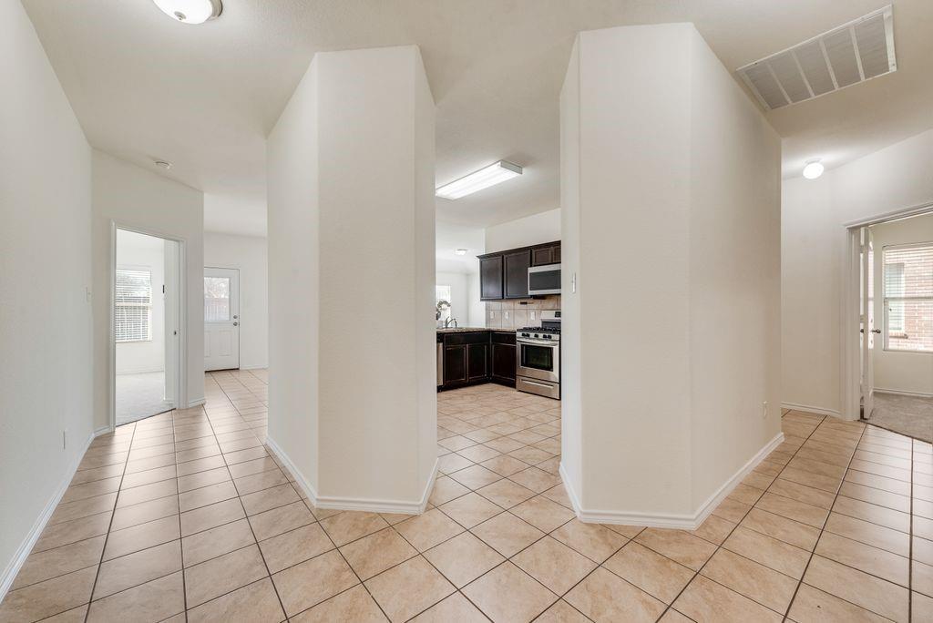 5117 Grayson Ridge Drive Fort Worth, TX 76179 - Photo 12 of 31 Hallway featuring healthy amount of natural light and light tile patterned floors
