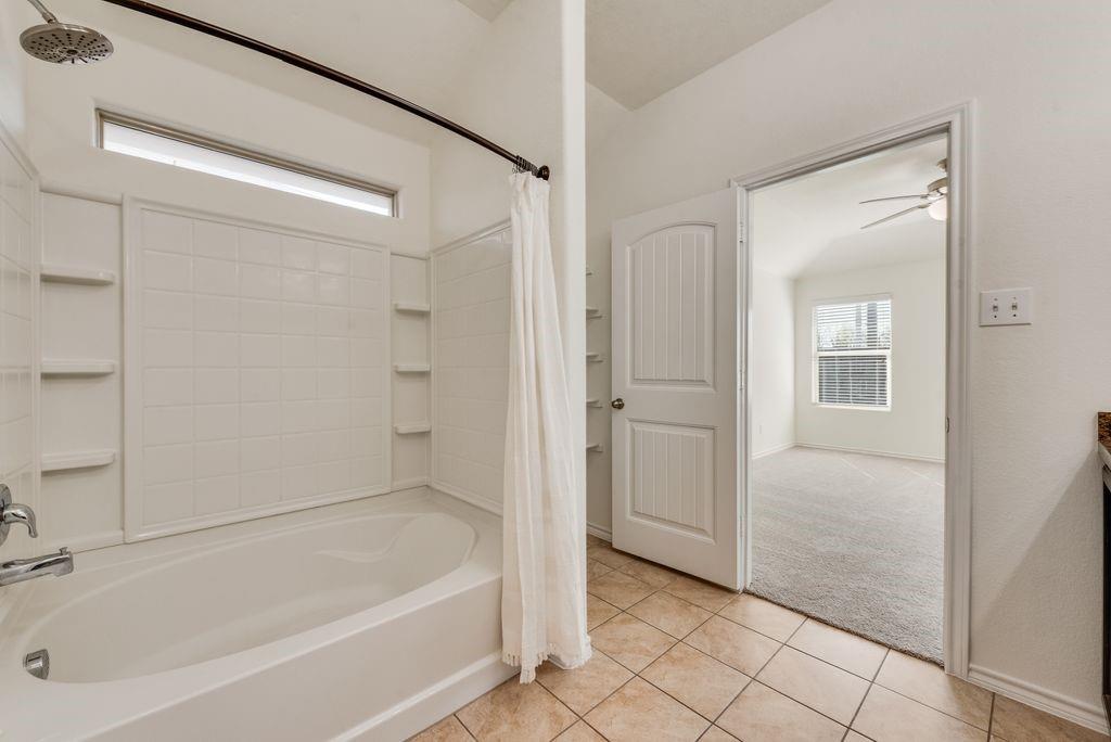 5117 Grayson Ridge Drive Fort Worth, TX 76179 - Photo 21 of 31 Full bath featuring vanity, light colored carpet, shower / tub combo with curtain, light tile patterned floors, and ceiling fan