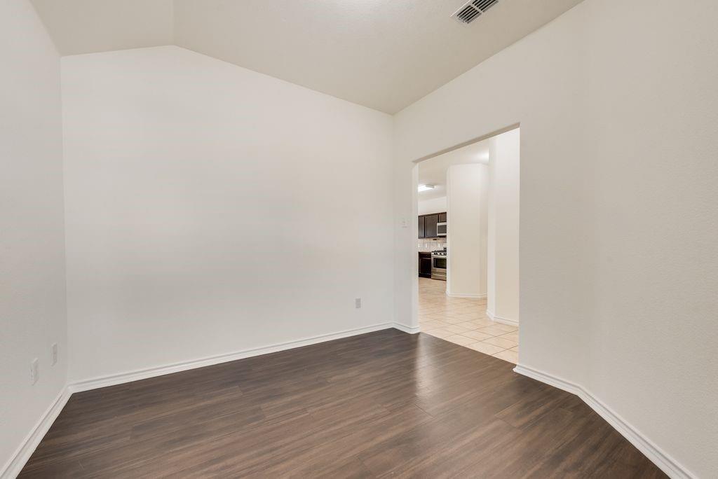 5117 Grayson Ridge Drive Fort Worth, TX 76179 - Photo 22 of 36 an empty room with wooden floor and natural light