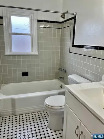 a bathroom with a granite countertop toilet a sink and bathtub