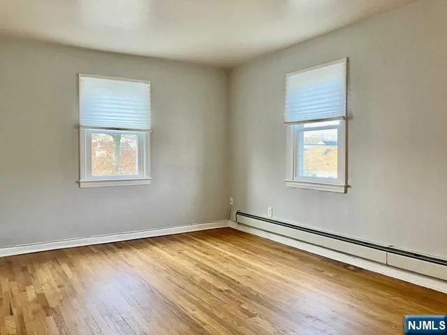 a view of a room with wooden floor and windows