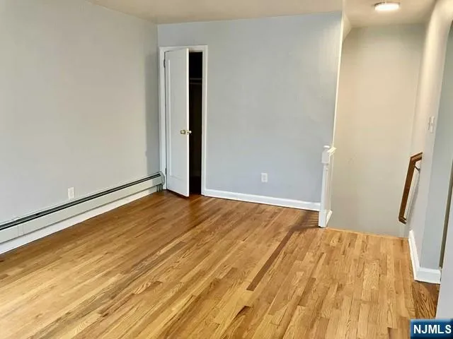 a view of empty room with wooden floor