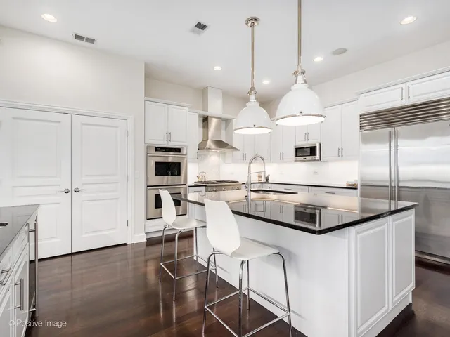 a kitchen with stainless steel appliances a stove a sink and a refrigerator