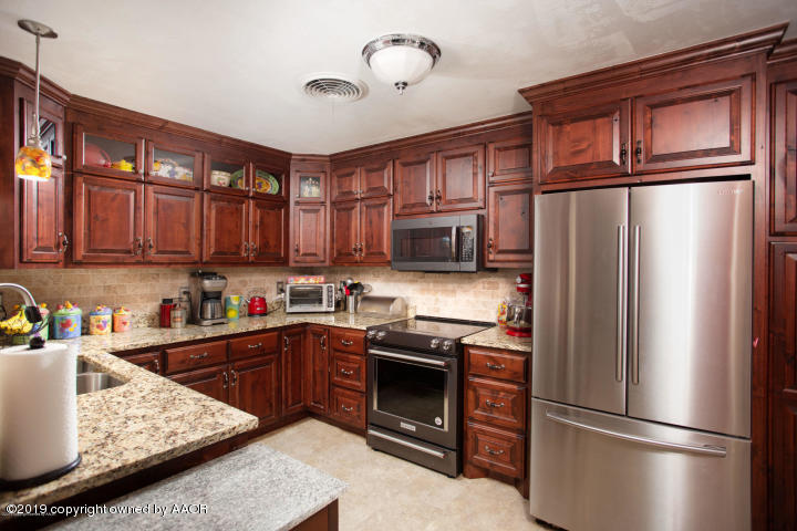 4013 South Travis Street Amarillo, TX 79110 - Photo 1 of 40 a kitchen with stainless steel appliances granite countertop a refrigerator stove top oven and sink
