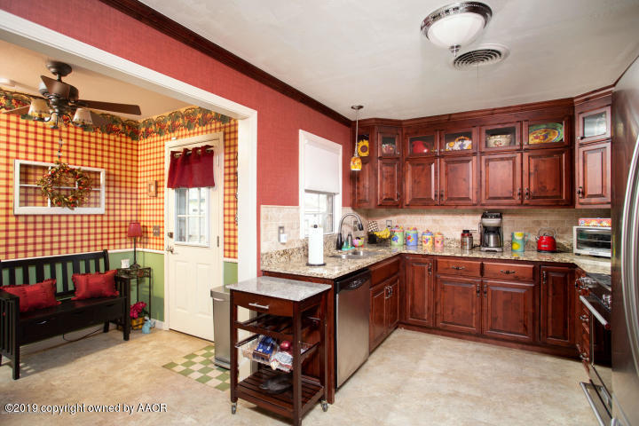 4013 South Travis Street Amarillo, TX 79110 - Photo 11 of 40 a kitchen with granite countertop a sink dishwasher stove and cabinets