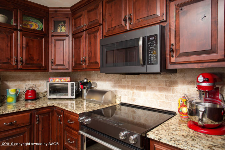 4013 South Travis Street Amarillo, TX 79110 - Photo 12 of 40 a kitchen with stainless steel appliances granite countertop a stove and cabinets