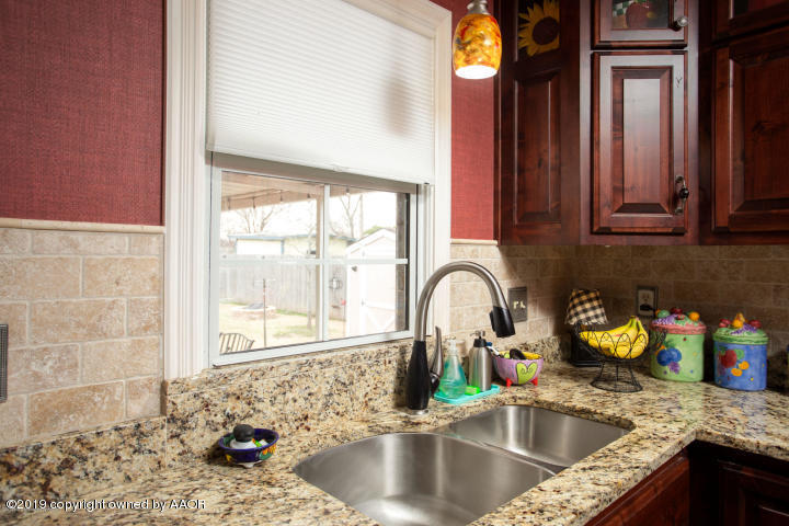 4013 South Travis Street Amarillo, TX 79110 - Photo 13 of 40 a kitchen with granite countertop a sink and a window