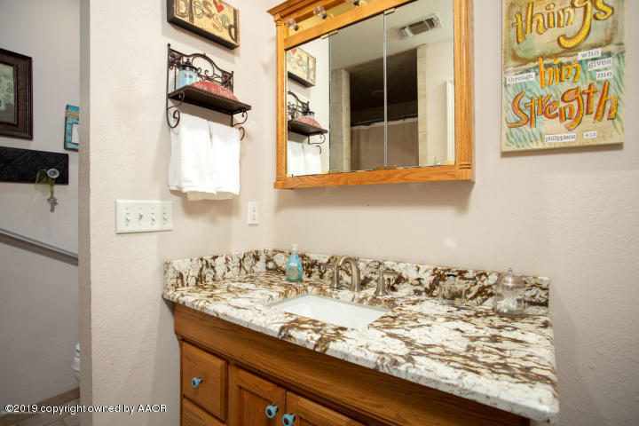 4013 South Travis Street Amarillo, TX 79110 - Photo 18 of 40 a bathroom with a granite countertop sink and a window