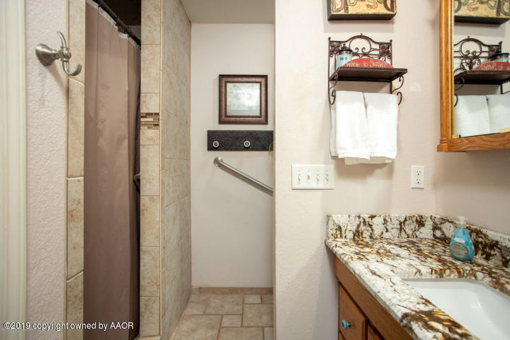 4013 South Travis Street Amarillo, TX 79110 - Photo 19 of 40 a bathroom with a sink and a mirror