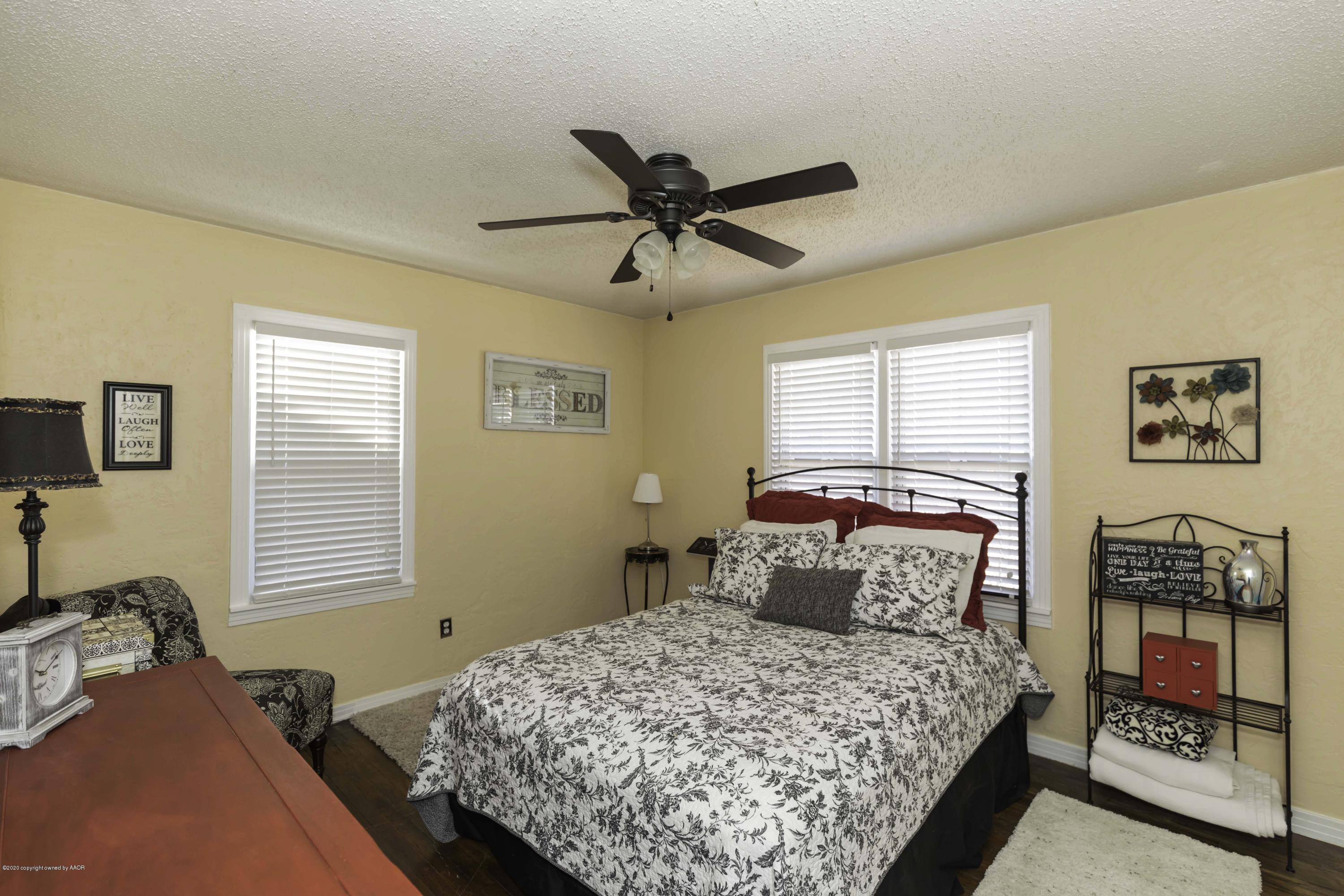 4013 South Travis Street Amarillo, TX 79110 - Photo 31 of 40 a bedroom with a bed and a chandelier