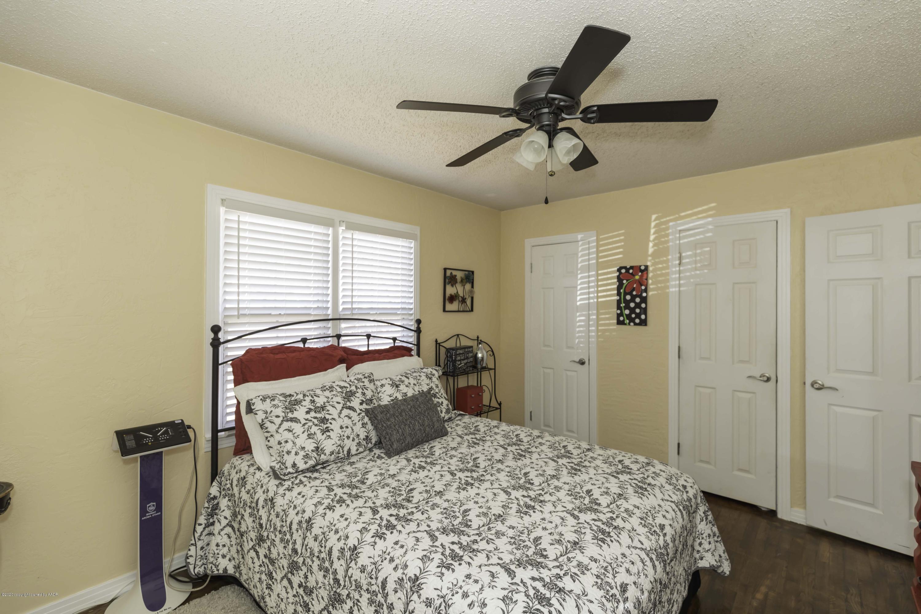 4013 South Travis Street Amarillo, TX 79110 - Photo 33 of 40 a bedroom with a bed and a chandelier