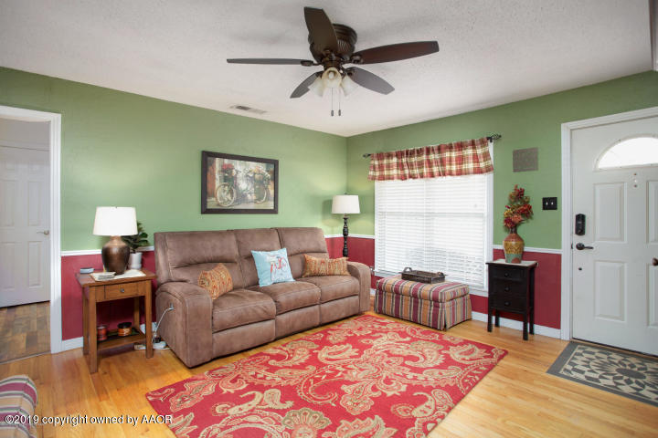 4013 South Travis Street Amarillo, TX 79110 - Photo 7 of 40 a living room with furniture ceiling fan and a rug