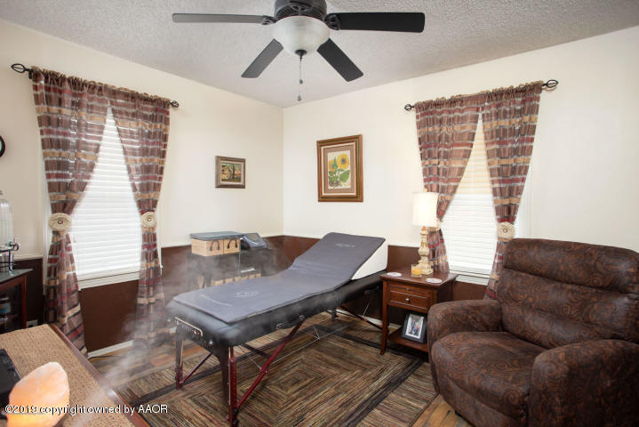 4013 South Travis Street Amarillo, TX 79110 - Photo 9 of 40 a living room with furniture a flat screen tv and a window