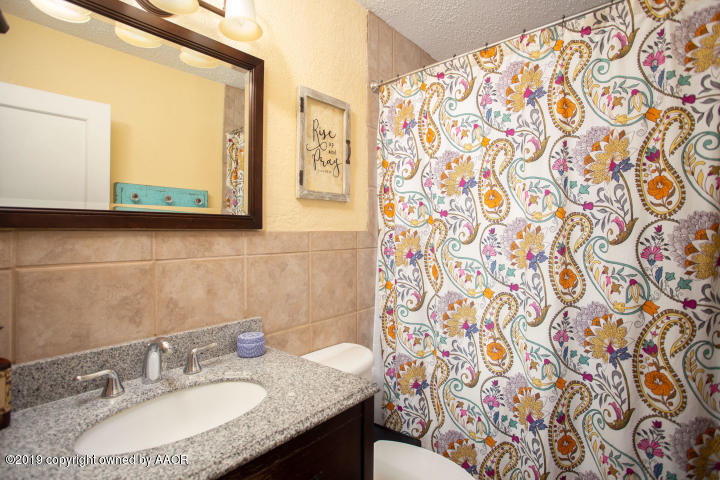 4013 South Travis Street Amarillo, TX 79110 - Photo 10 of 40 a bathroom with a granite countertop sink and a mirror