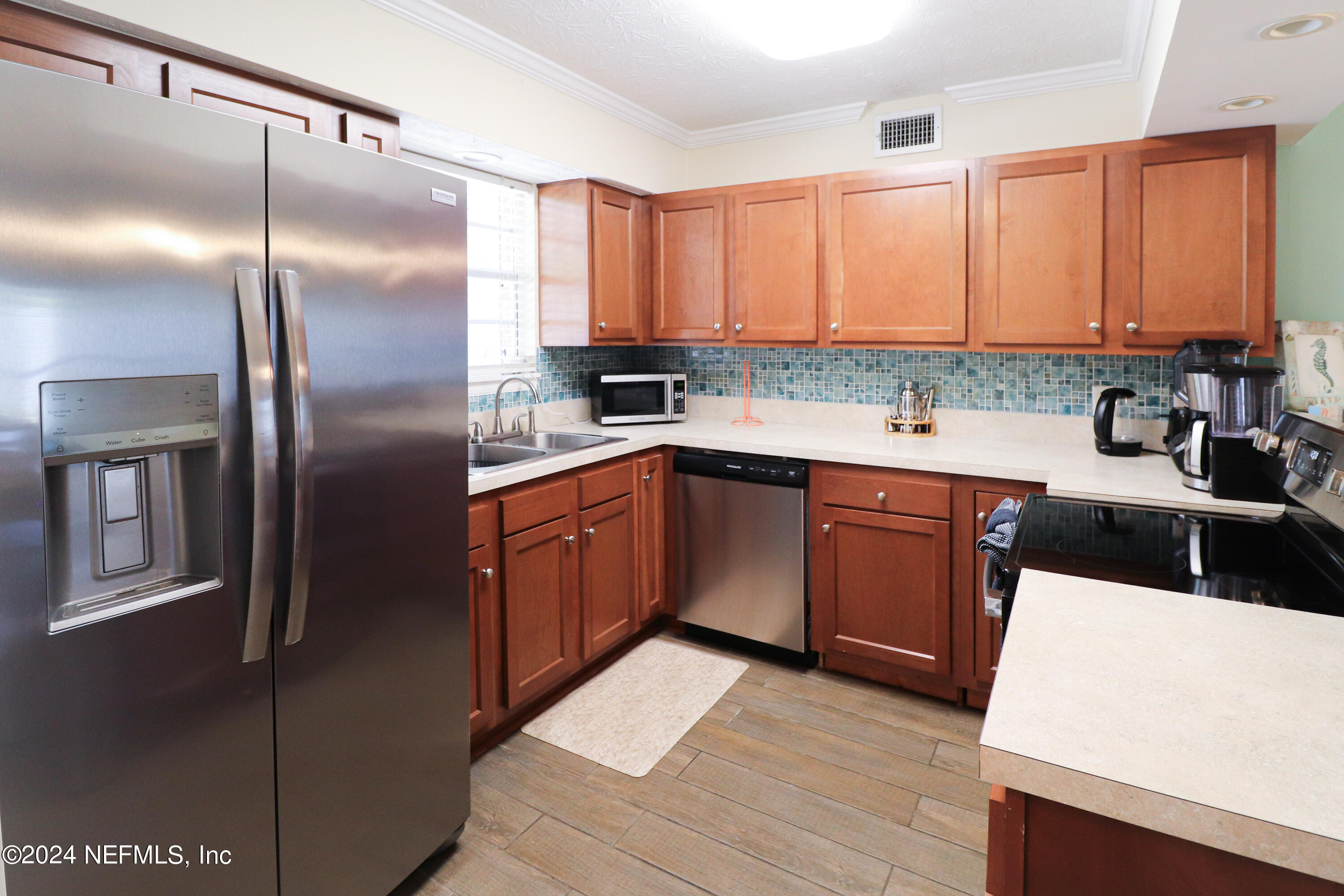 317 Flagler Boulevard, Unit 4A St. Augustine, FL 32080 - Photo 3 of 19 a kitchen with a sink a refrigerator and cabinets