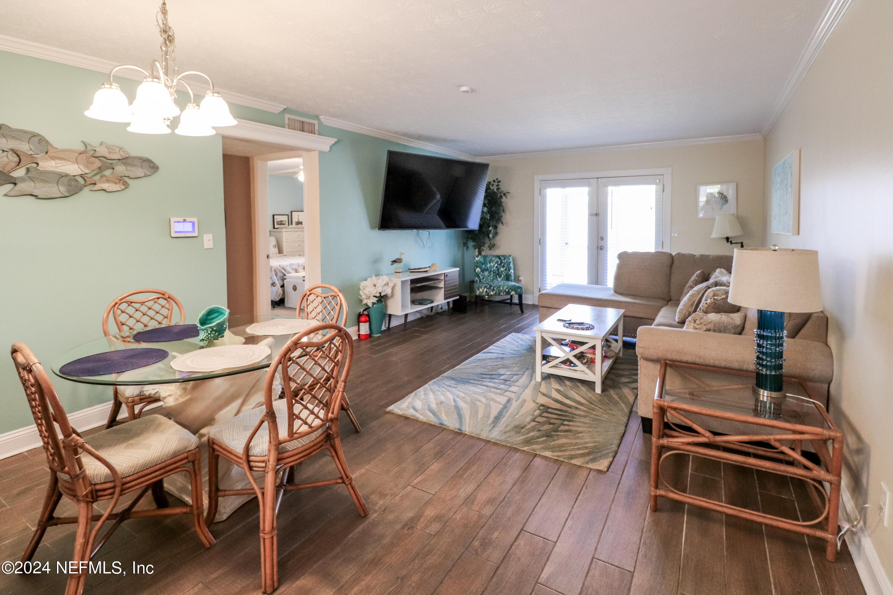 317 Flagler Boulevard, Unit 4A St. Augustine, FL 32080 - Photo 6 of 19 a living room with furniture a flat screen tv and kitchen view