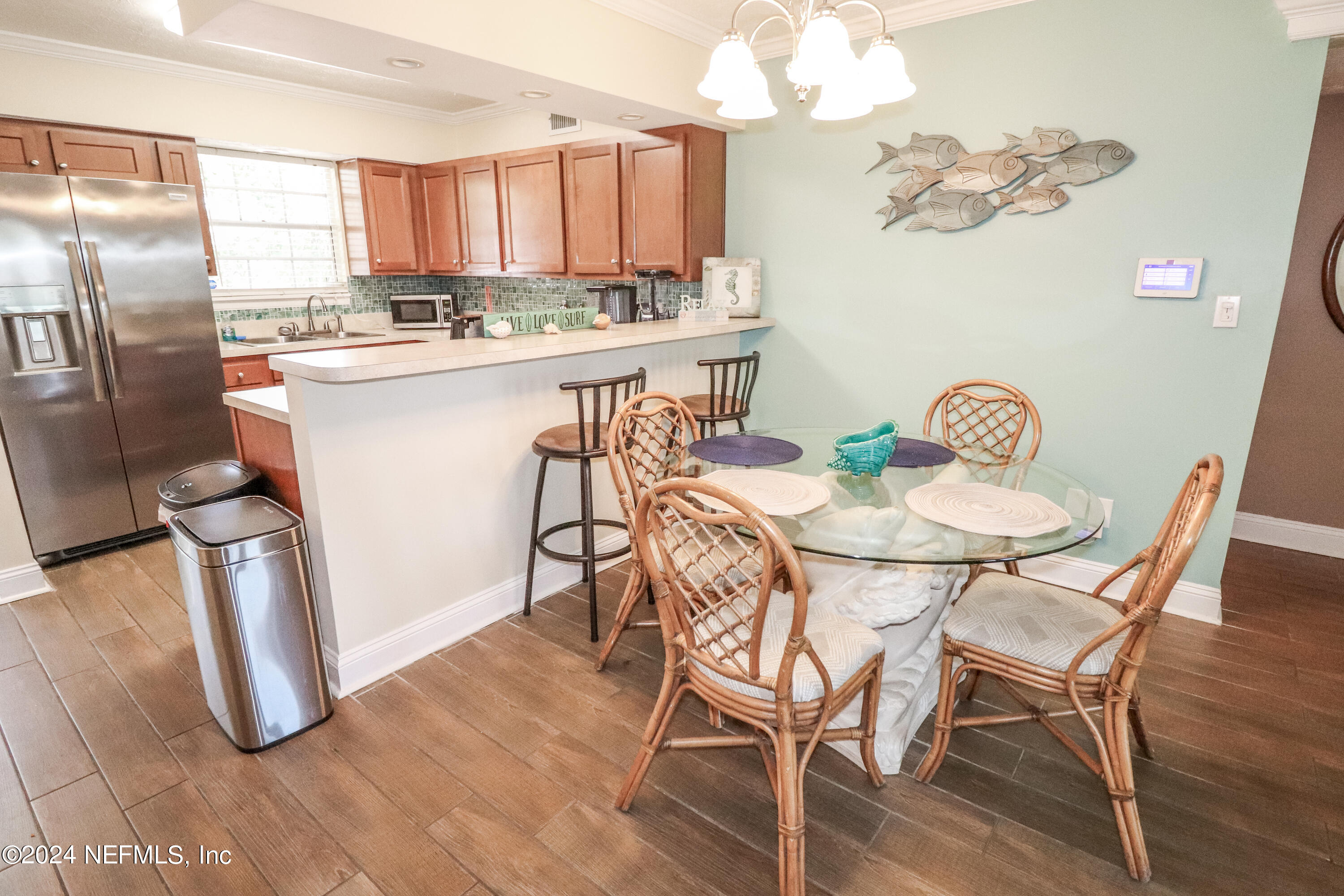 317 Flagler Boulevard, Unit 4A St. Augustine, FL 32080 - Photo 10 of 19 a view of a dining room with furniture a chandelier and wooden floor