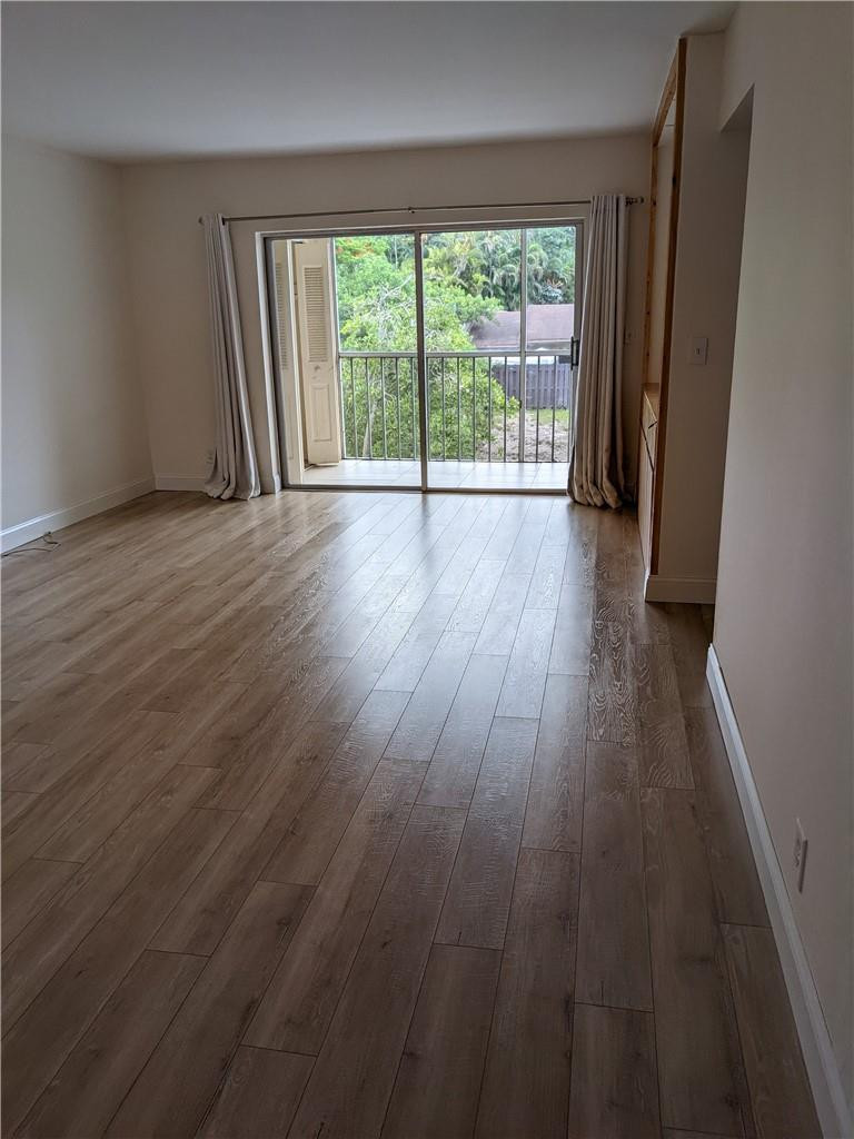 9280 Southwest 3rd Street, Unit 810 Boca Raton, FL 33428 - Photo 6 of 22 an empty room with wooden floor and windows