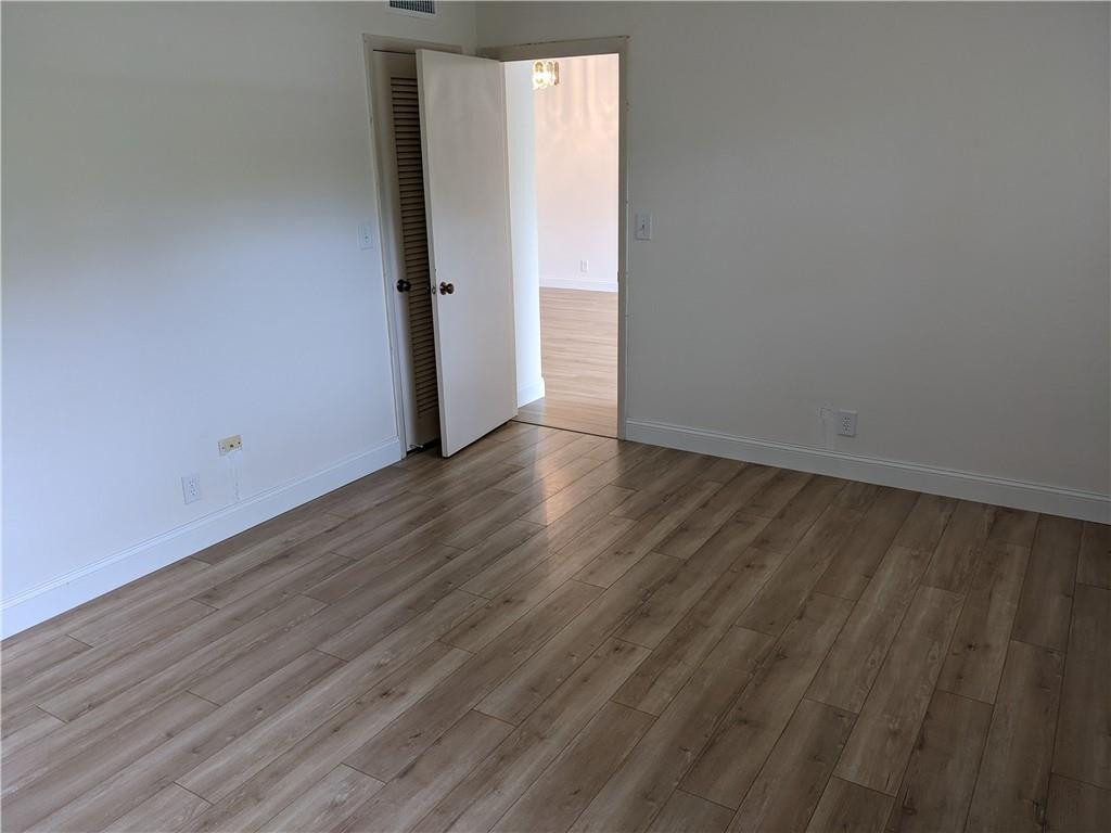 9280 Southwest 3rd Street, Unit 810 Boca Raton, FL 33428 - Photo 8 of 22 a view of an empty room with wooden floor and a window