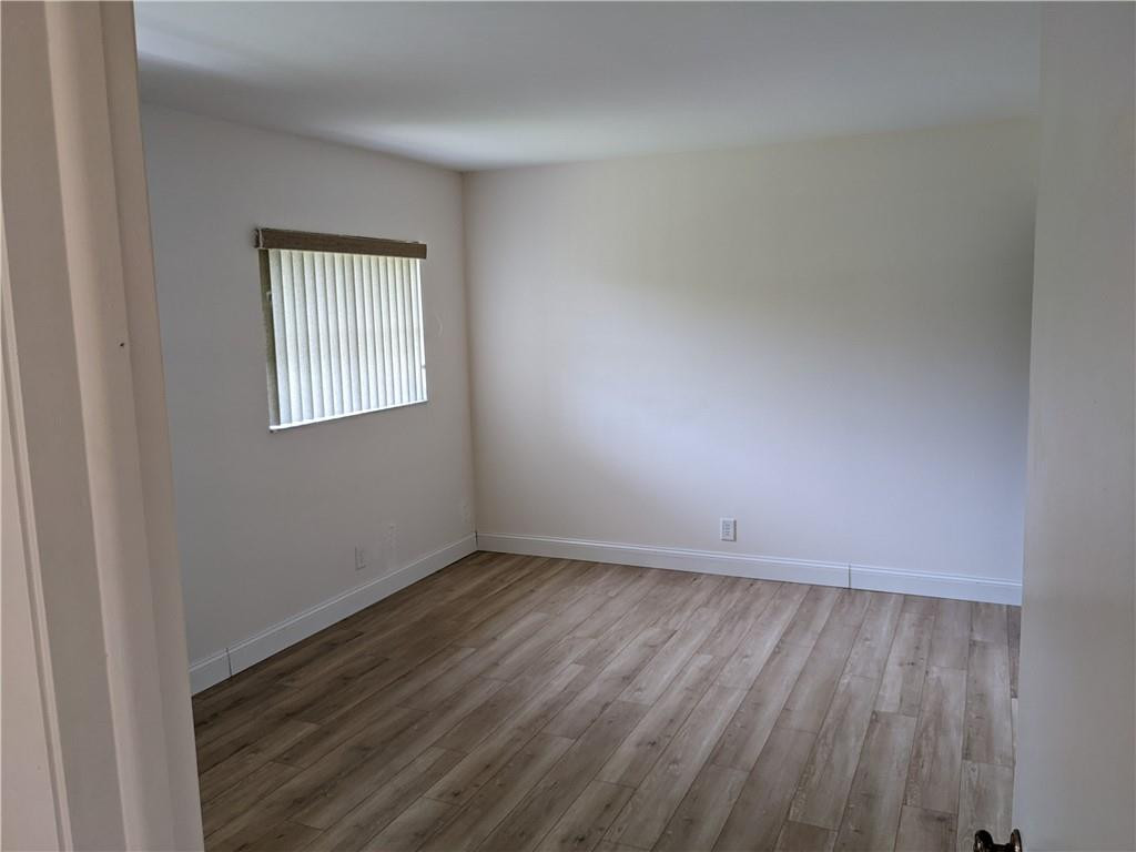 9280 Southwest 3rd Street, Unit 810 Boca Raton, FL 33428 - Photo 9 of 22 an empty room with wooden floor and windows