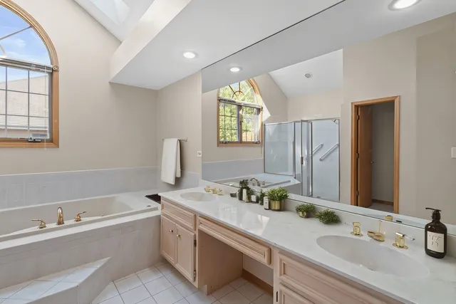 a bathroom with a tub sink and mirror