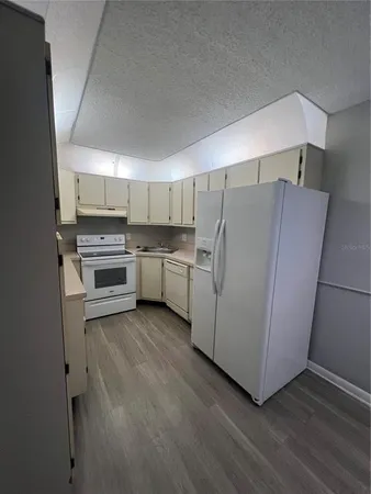 a kitchen with wooden cabinets and white appliances