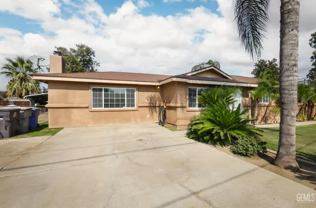 a view of a house with backyard and sitting area