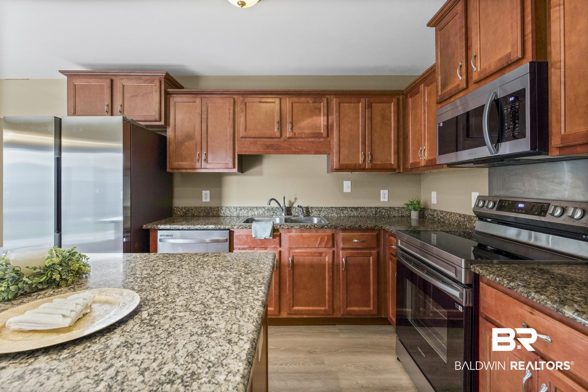 2084 Redpine Drive Semmes, AL 36575 - Photo 8 of 22 Kitchen with stainless steel appliances, light wood-type flooring, dark stone countertops, and brown cabinets