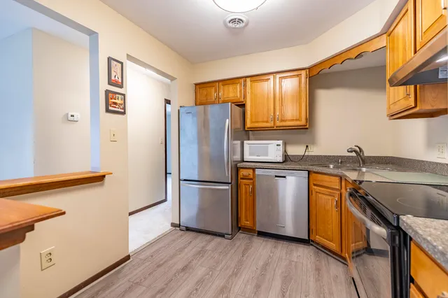 a kitchen with granite countertop stainless steel appliances a refrigerator a sink and a stove