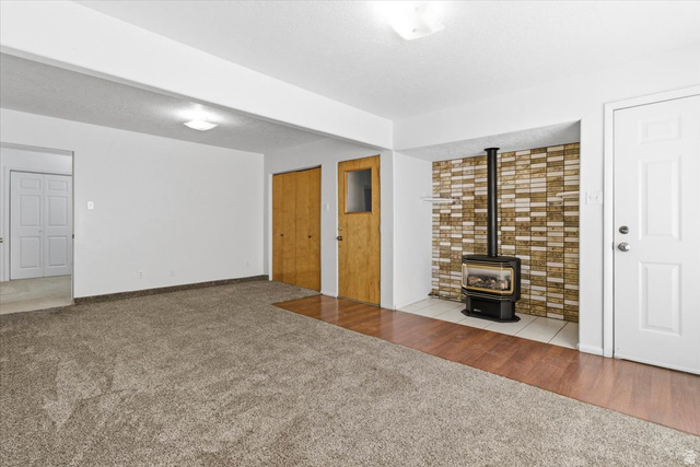 217 East 400 South Spring City, UT 84662 - Photo 4 of 71 Unfurnished living room featuring carpet flooring and a wood stove