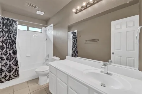 a bathroom with a double vanity sink toilet and shower