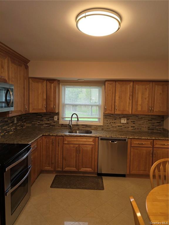 2115 State Rte 55, Unit 1 LaGrangeville, NY 12540 - Photo 15 of 23 a kitchen with stainless steel appliances granite countertop a sink stove and cabinets
