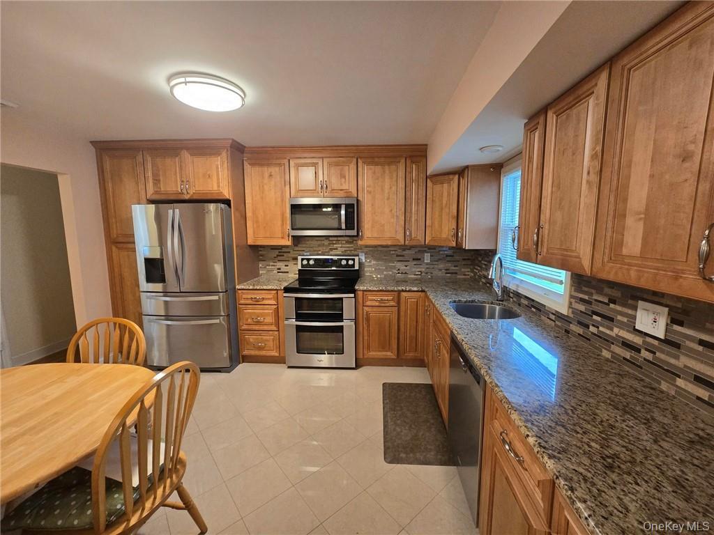 2115 State Rte 55, Unit 1 LaGrangeville, NY 12540 - Photo 4 of 23 a kitchen with stainless steel appliances a stove a sink a refrigerator white cabinets and wooden floor