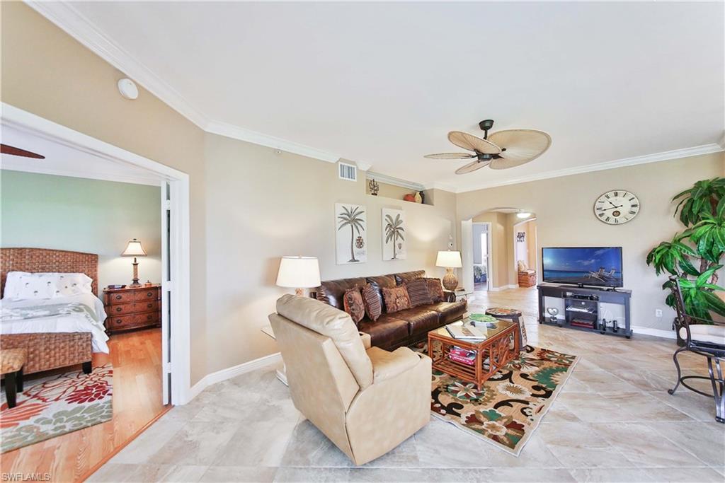 5105 Cedar Springs Drive, Unit 101 Naples, FL 34110 - Photo 13 of 30 a living room with furniture and a flat screen tv