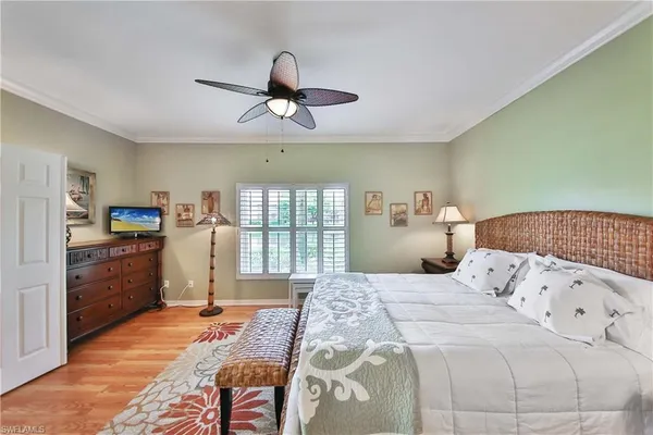a bedroom with a bed dresser and a large window