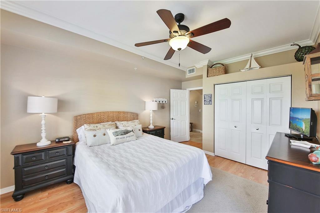 5105 Cedar Springs Drive, Unit 101 Naples, FL 34110 - Photo 20 of 30 a bedroom with a bed and a chandelier