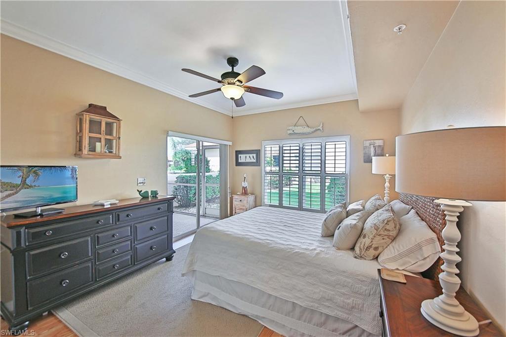 5105 Cedar Springs Drive, Unit 101 Naples, FL 34110 - Photo 21 of 30 a bedroom with a bed and a chandelier