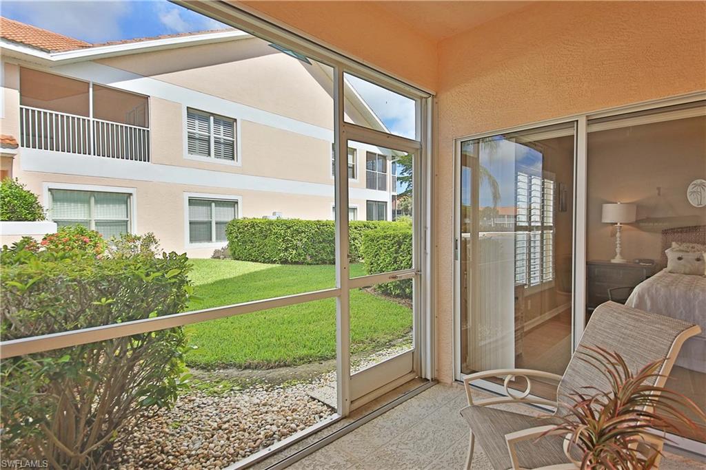 5105 Cedar Springs Drive, Unit 101 Naples, FL 34110 - Photo 26 of 30 a view of a balcony with a floor to ceiling window and wooden fence