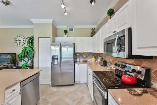 a kitchen with stainless steel appliances a stove a refrigerator and a sink