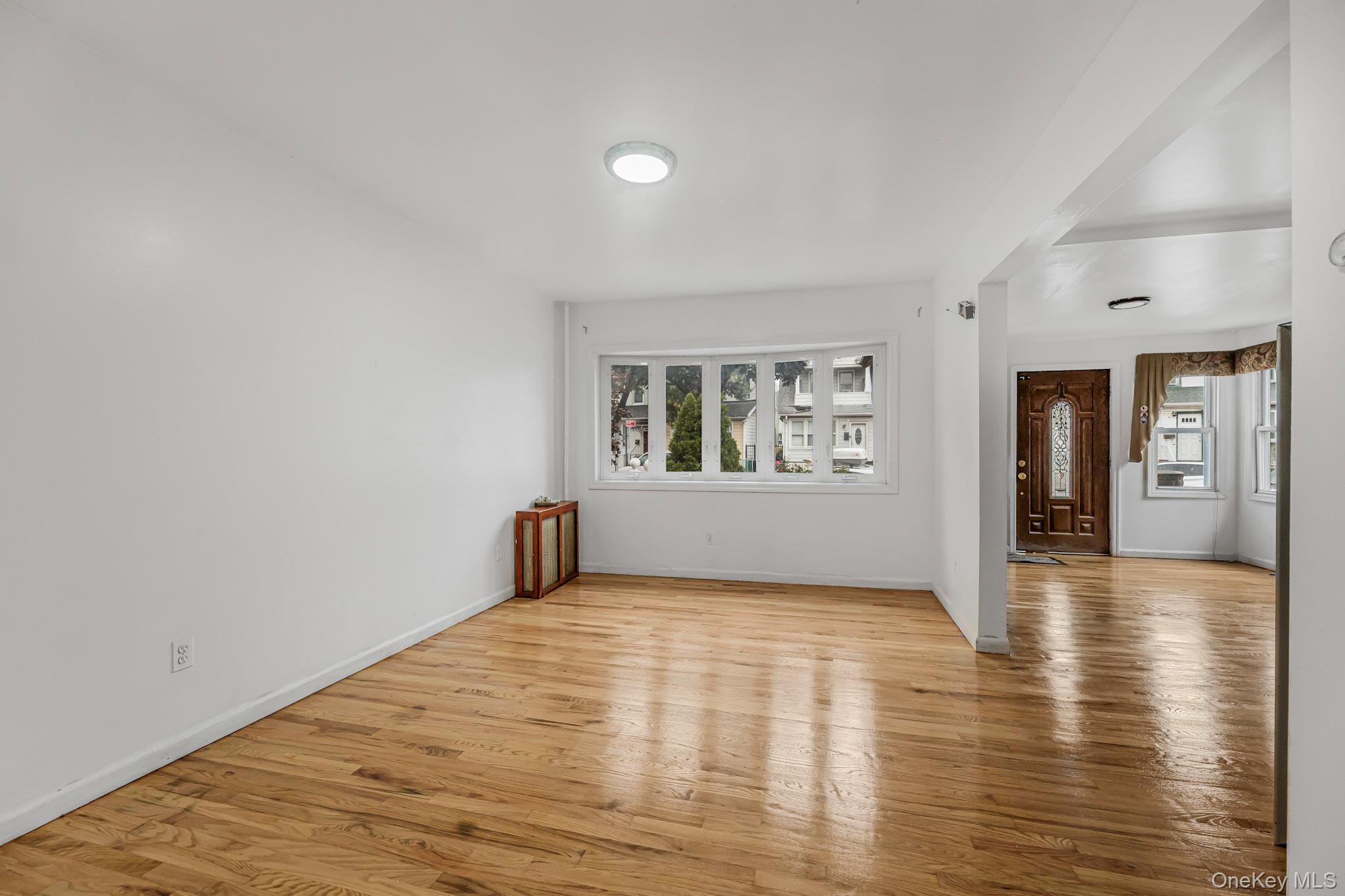 90-06 107th Avenue Queens, NY 11417 - Photo 4 of 13 a view of an empty room with window and wooden floor