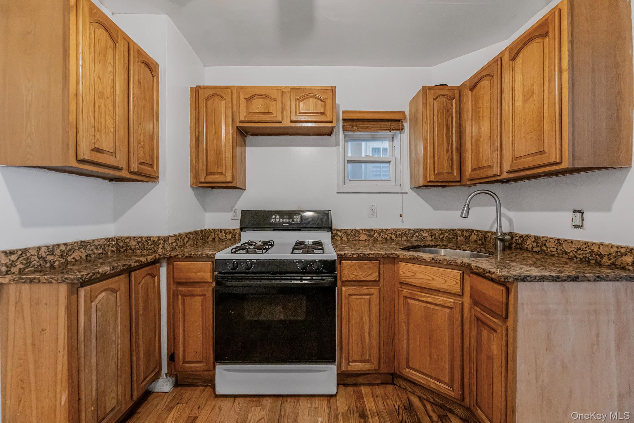 90-06 107th Avenue Queens, NY 11417 - Photo 5 of 13 a kitchen with stainless steel appliances granite countertop a stove a sink and a microwave