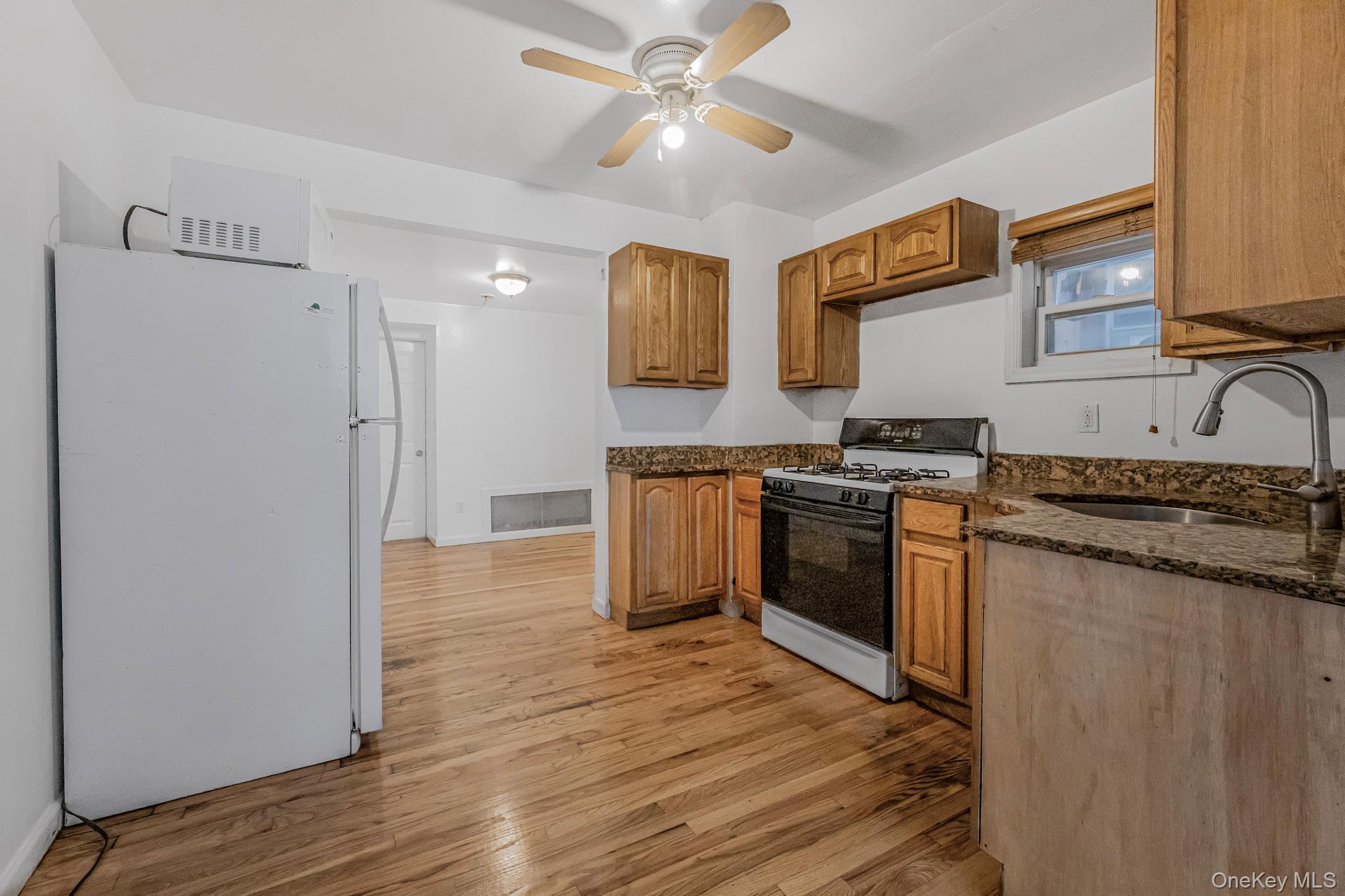 90-06 107th Avenue Queens, NY 11417 - Photo 6 of 13 a kitchen with stainless steel appliances granite countertop a stove and a refrigerator