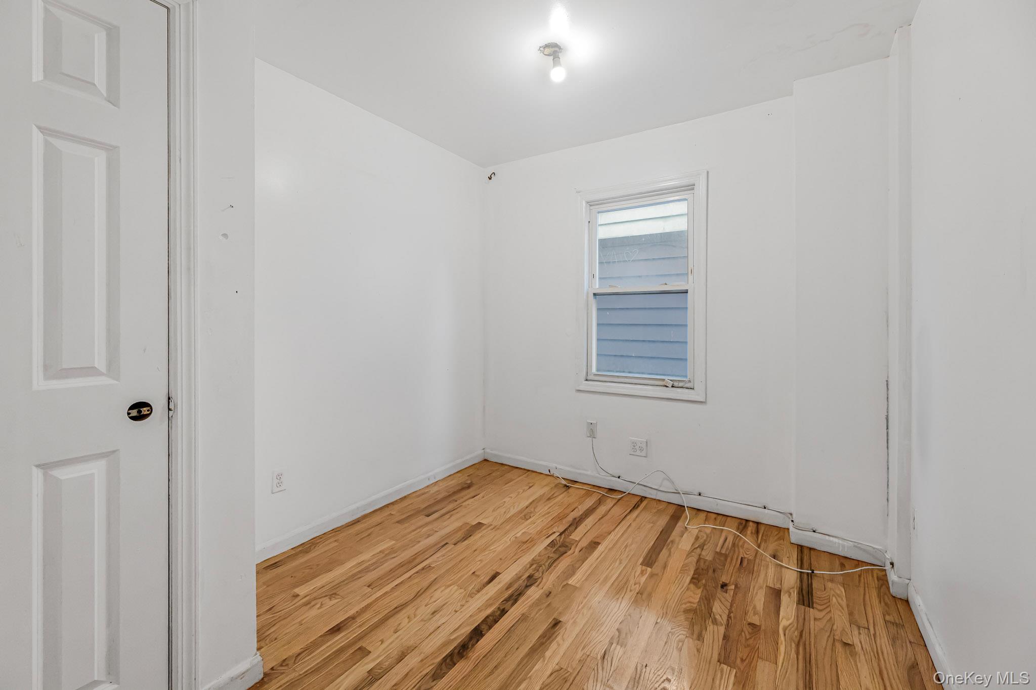 90-06 107th Avenue Queens, NY 11417 - Photo 9 of 13 a view of a room with wooden floor and a window