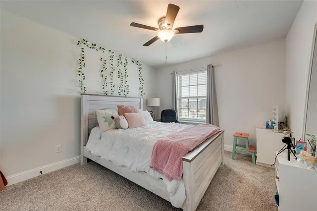 a bedroom with a bed chandelier and a window